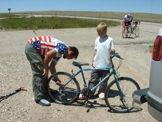 Gerard changing boy's flat tire